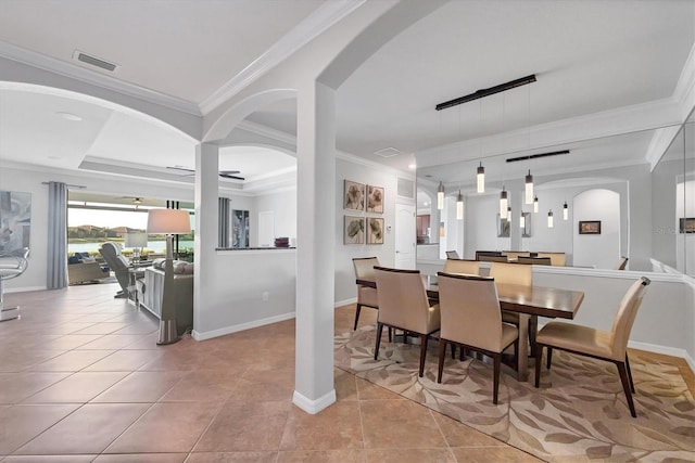 dining area featuring visible vents, ornamental molding, arched walkways, light tile patterned floors, and baseboards