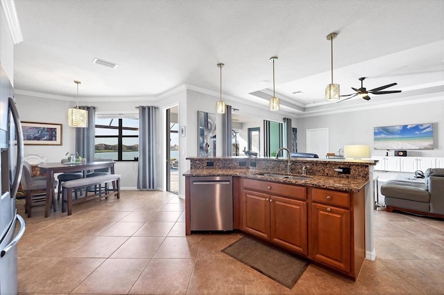 kitchen featuring brown cabinetry, a sink, appliances with stainless steel finishes, crown molding, and open floor plan