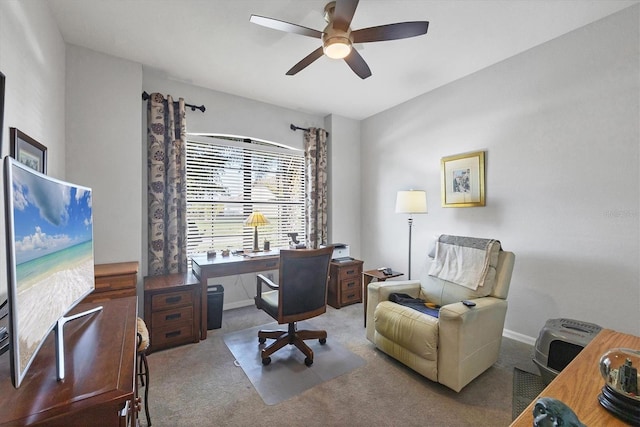 carpeted home office featuring baseboards and ceiling fan