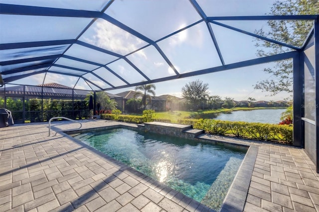 pool featuring glass enclosure, a patio, and a water view