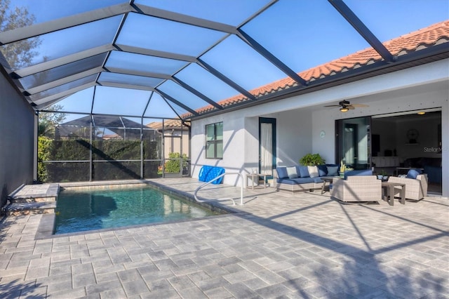 view of pool featuring glass enclosure, an outdoor hangout area, a ceiling fan, and a patio