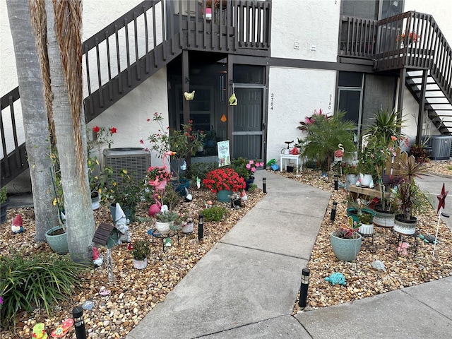 property entrance featuring cooling unit and stucco siding