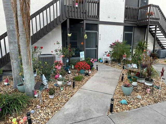 property entrance featuring central AC and stucco siding