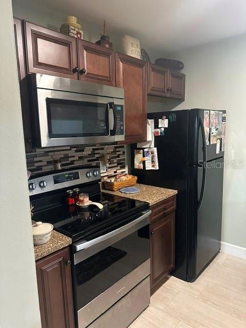 kitchen with light stone counters, baseboards, tasteful backsplash, and stainless steel appliances