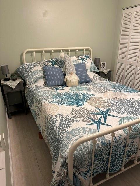 bedroom with wood finished floors and a closet