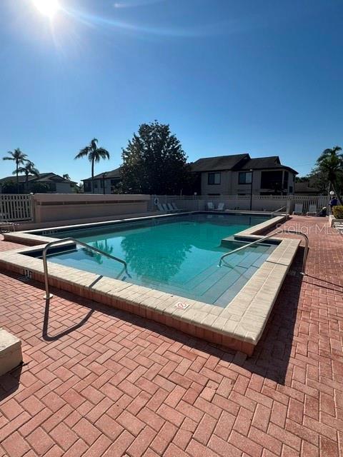 pool with a patio and fence