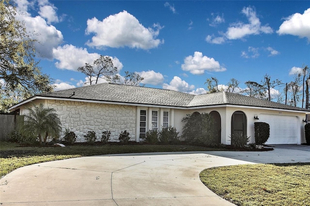 view of front of property featuring stone siding, driveway, and an attached garage