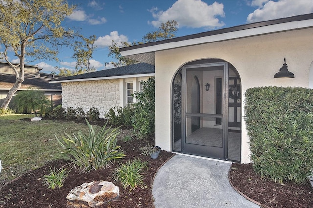 doorway to property with stone siding and stucco siding