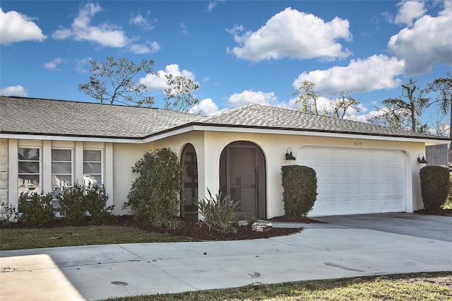 view of front of house with an attached garage, driveway, and stucco siding