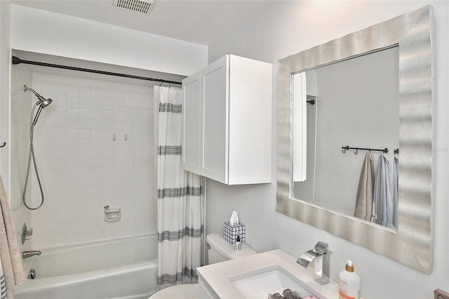 bathroom with visible vents, vanity, toilet, and shower / tub combo