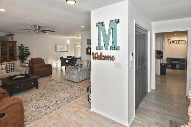 interior space with baseboards, a ceiling fan, and wood finished floors