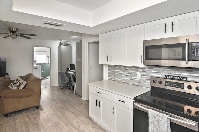 kitchen featuring visible vents, tasteful backsplash, open floor plan, stainless steel appliances, and light wood-style floors