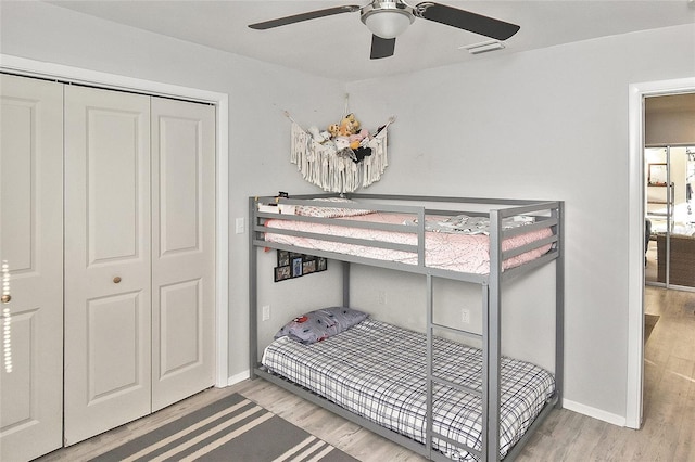 bedroom featuring wood finished floors, baseboards, and a closet