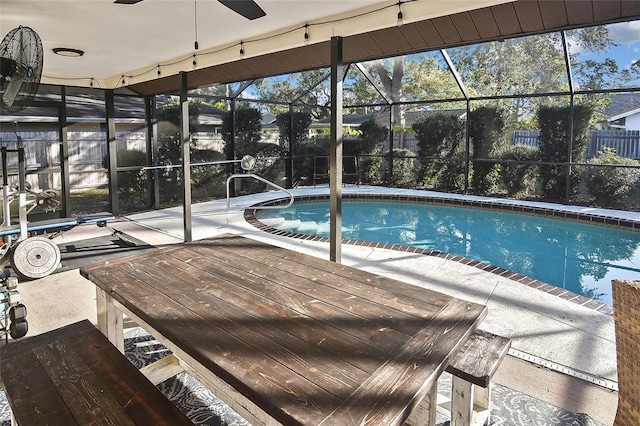 pool with a lanai, a patio, and fence