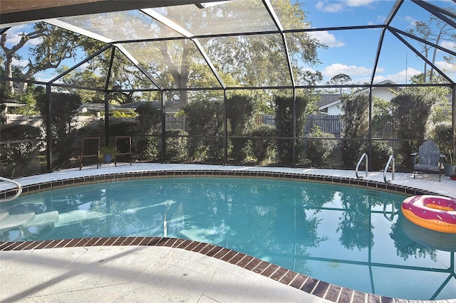 pool featuring a patio area, glass enclosure, and fence