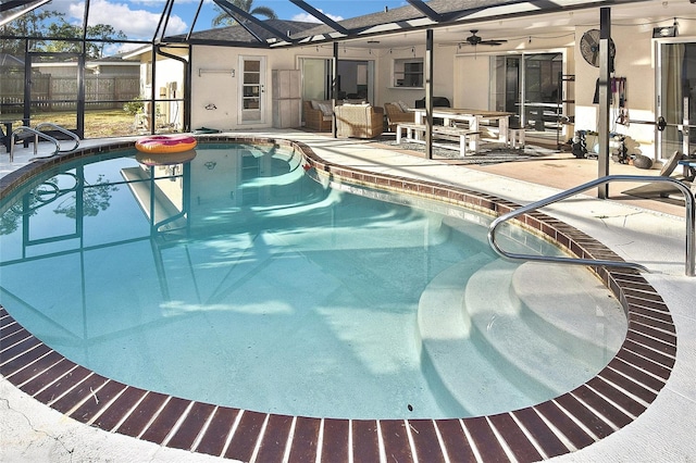 outdoor pool with glass enclosure, a patio, and fence