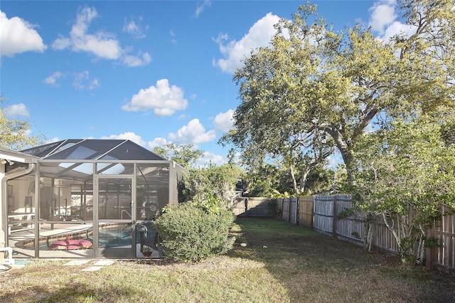 view of yard featuring a lanai, a fenced backyard, and a fenced in pool