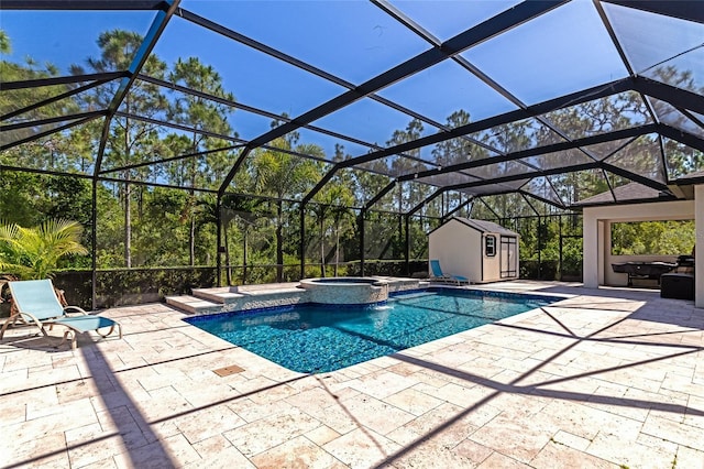 view of swimming pool featuring a pool with connected hot tub, glass enclosure, a storage shed, an outbuilding, and a patio