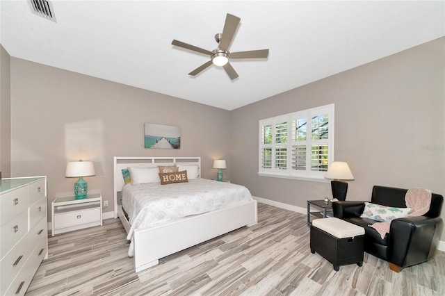 bedroom featuring visible vents, baseboards, light wood-style flooring, and a ceiling fan