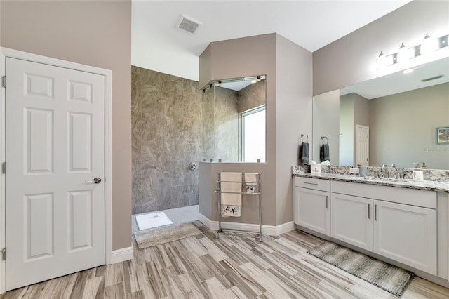 full bath featuring visible vents, walk in shower, wood finished floors, and vanity