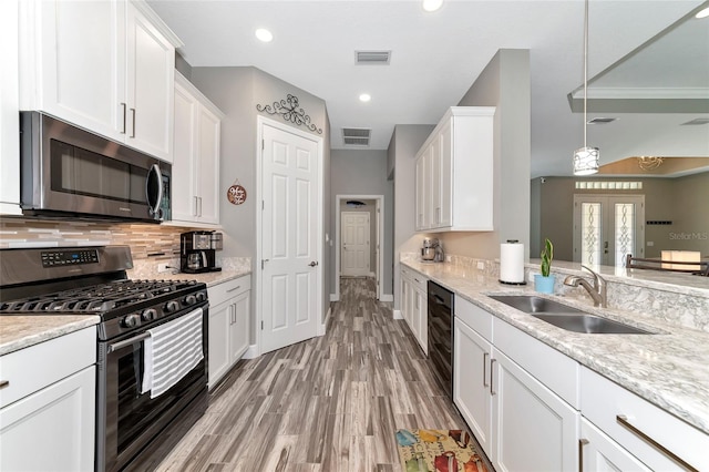 kitchen featuring decorative backsplash, white cabinetry, stainless steel appliances, and a sink