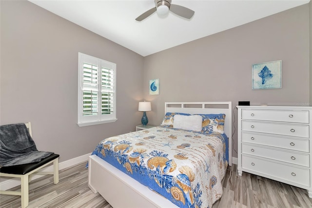 bedroom featuring light wood finished floors, ceiling fan, and baseboards