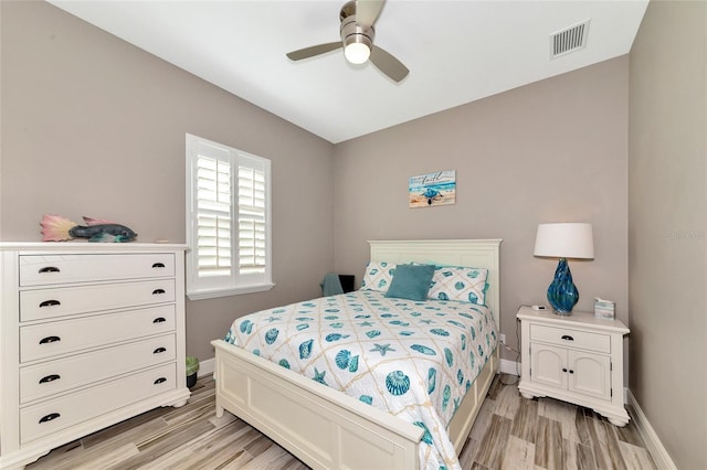 bedroom with light wood-style floors, visible vents, and baseboards