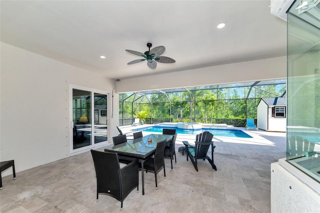 view of patio / terrace featuring a lanai, outdoor dining space, a pool with connected hot tub, and ceiling fan