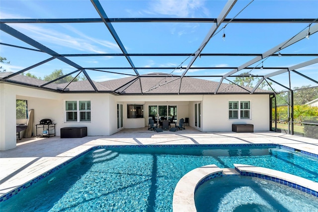 view of swimming pool featuring a lanai, a pool with connected hot tub, and a patio