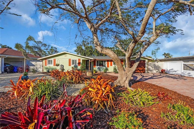 ranch-style house featuring stucco siding, driveway, a garage, and fence