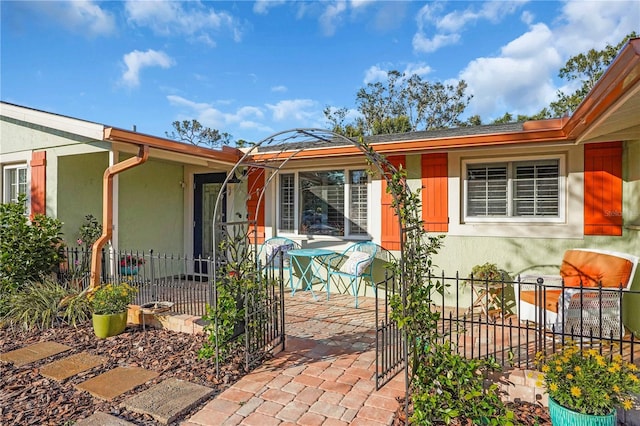 exterior space with a patio, fence, and stucco siding