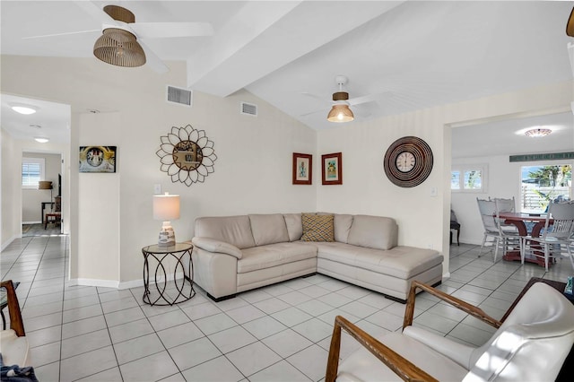 living area featuring light tile patterned flooring, visible vents, lofted ceiling with beams, and a ceiling fan