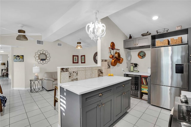 kitchen with vaulted ceiling with beams, light tile patterned flooring, stainless steel refrigerator with ice dispenser, and gray cabinetry