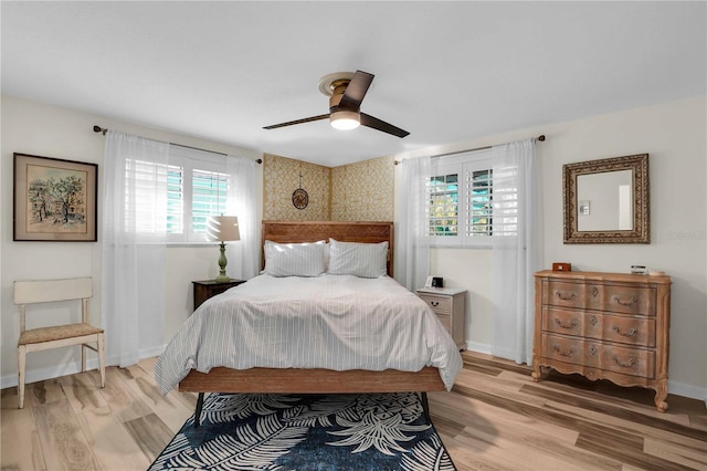 bedroom with ceiling fan, light wood-type flooring, and baseboards