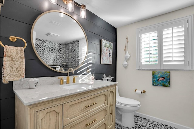 full bath with toilet, vanity, and baseboards