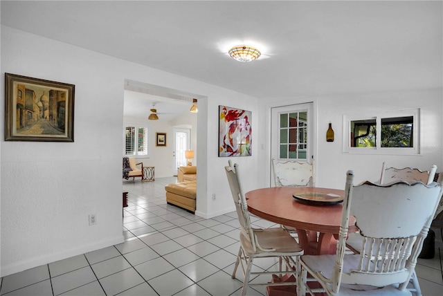 dining room with light tile patterned flooring, plenty of natural light, and baseboards
