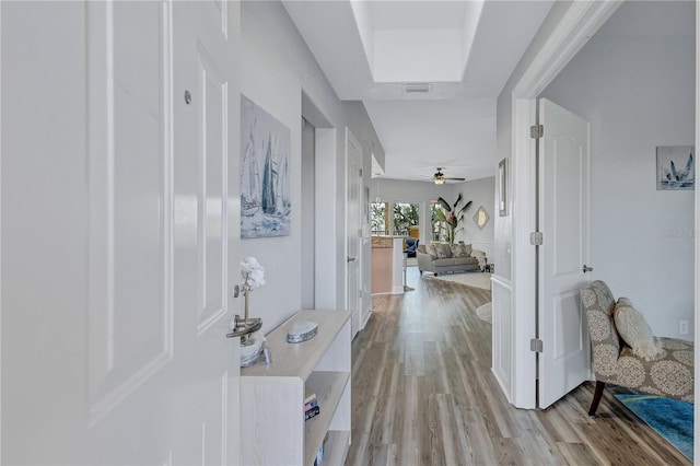 hallway featuring light wood finished floors and visible vents