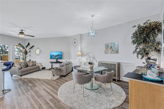 dining area with a wainscoted wall, ceiling fan, and wood finished floors