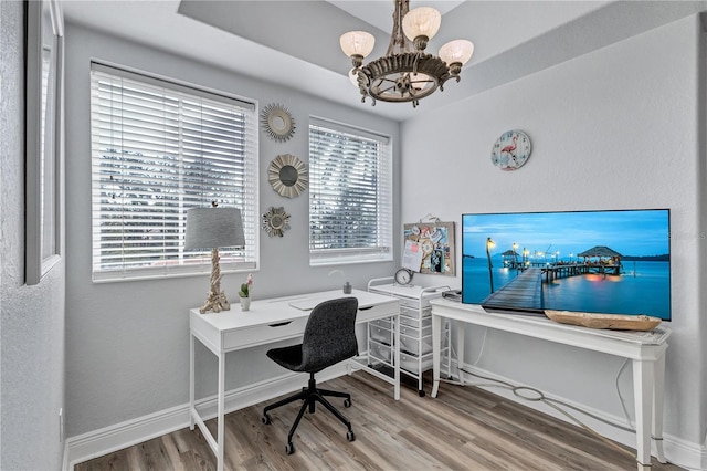 office space featuring a notable chandelier, baseboards, and wood finished floors