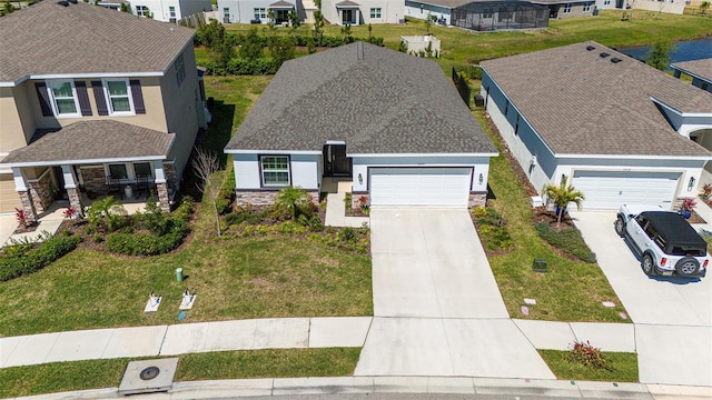 view of front of home with an attached garage, stucco siding, concrete driveway, stone siding, and a residential view