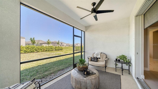 sunroom with a residential view and a ceiling fan