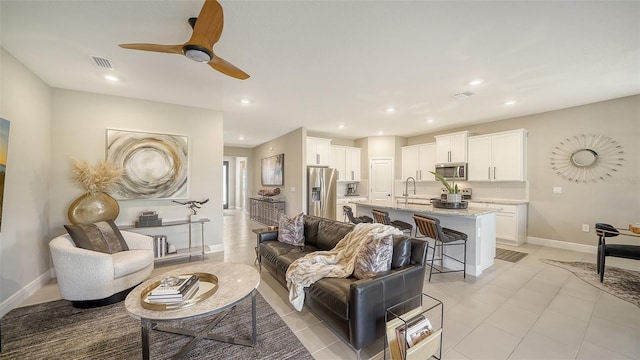 living room with visible vents, recessed lighting, a ceiling fan, and baseboards