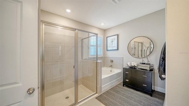 bathroom with vanity, a bath, and a shower stall