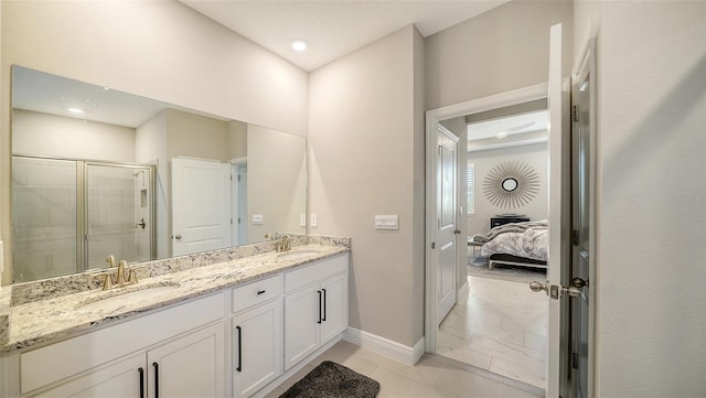 ensuite bathroom featuring a shower stall, double vanity, marble finish floor, and a sink