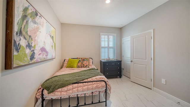 bedroom with baseboards and marble finish floor