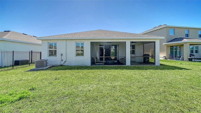 rear view of property with fence, a lawn, stucco siding, a sunroom, and a ceiling fan