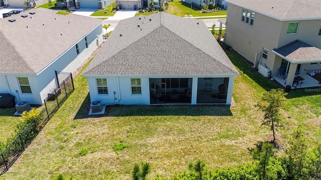 rear view of property featuring a residential view, cooling unit, a yard, and a sunroom