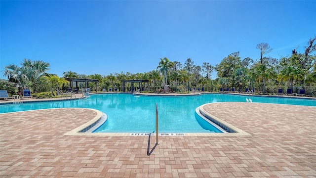 pool with a patio area and a pergola