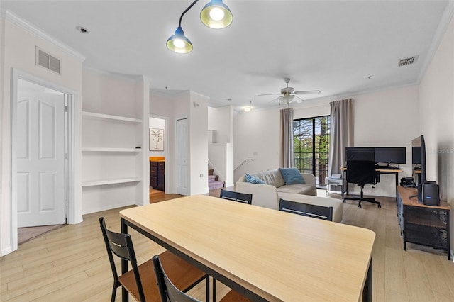 dining area with visible vents, light wood-style flooring, and ornamental molding