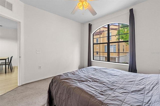 carpeted bedroom with visible vents, ceiling fan, and baseboards